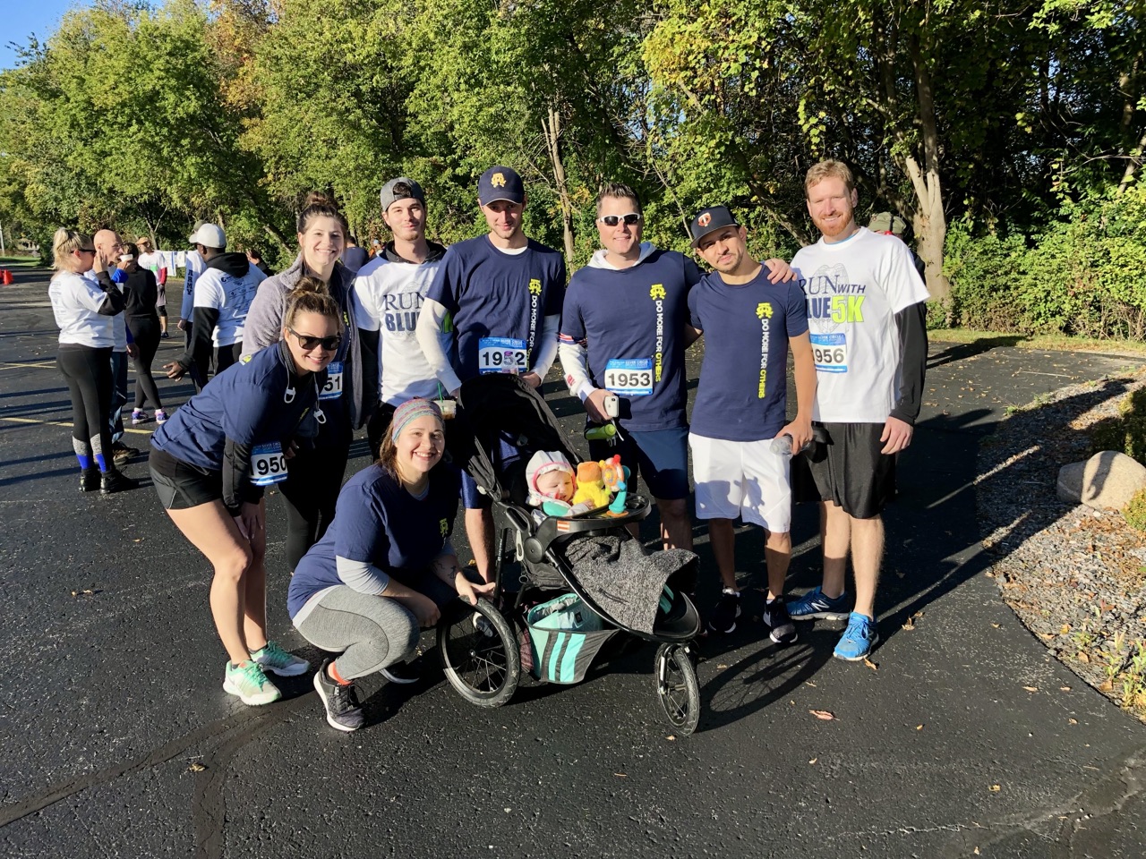 James and the team with race bibs at the Run with the Blue 5K charity event